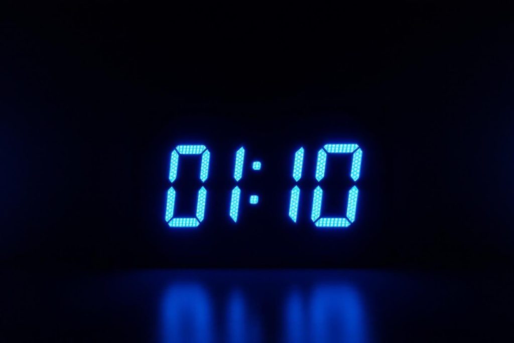 Affichage digital montrant l'heure 01:10 sur fond noir