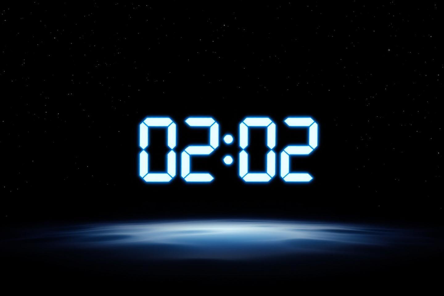 Affichage numérique montrant 02:02 sur fond spatial sombre